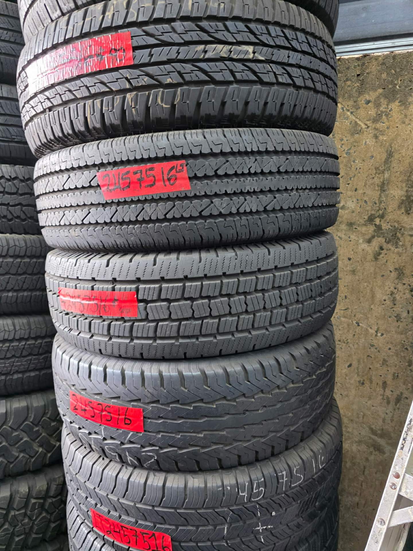 Stacks of new and used truck and SUV tires with size tags